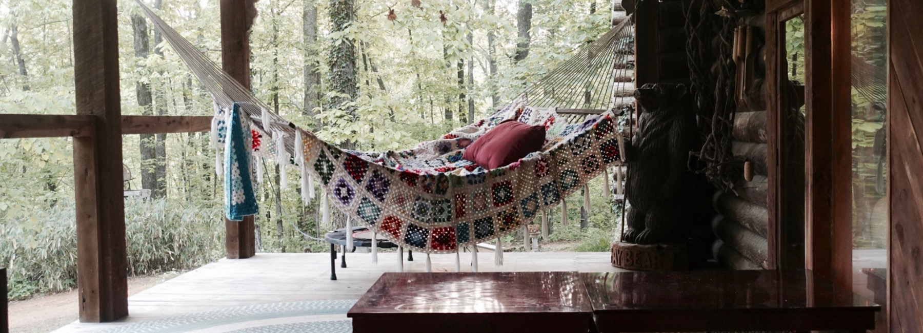 hammock on a porch with forest in background