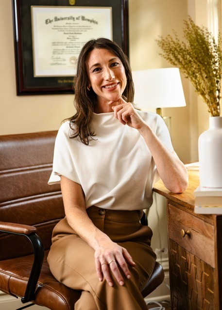 A woman with brown hair smiling and looking at camera