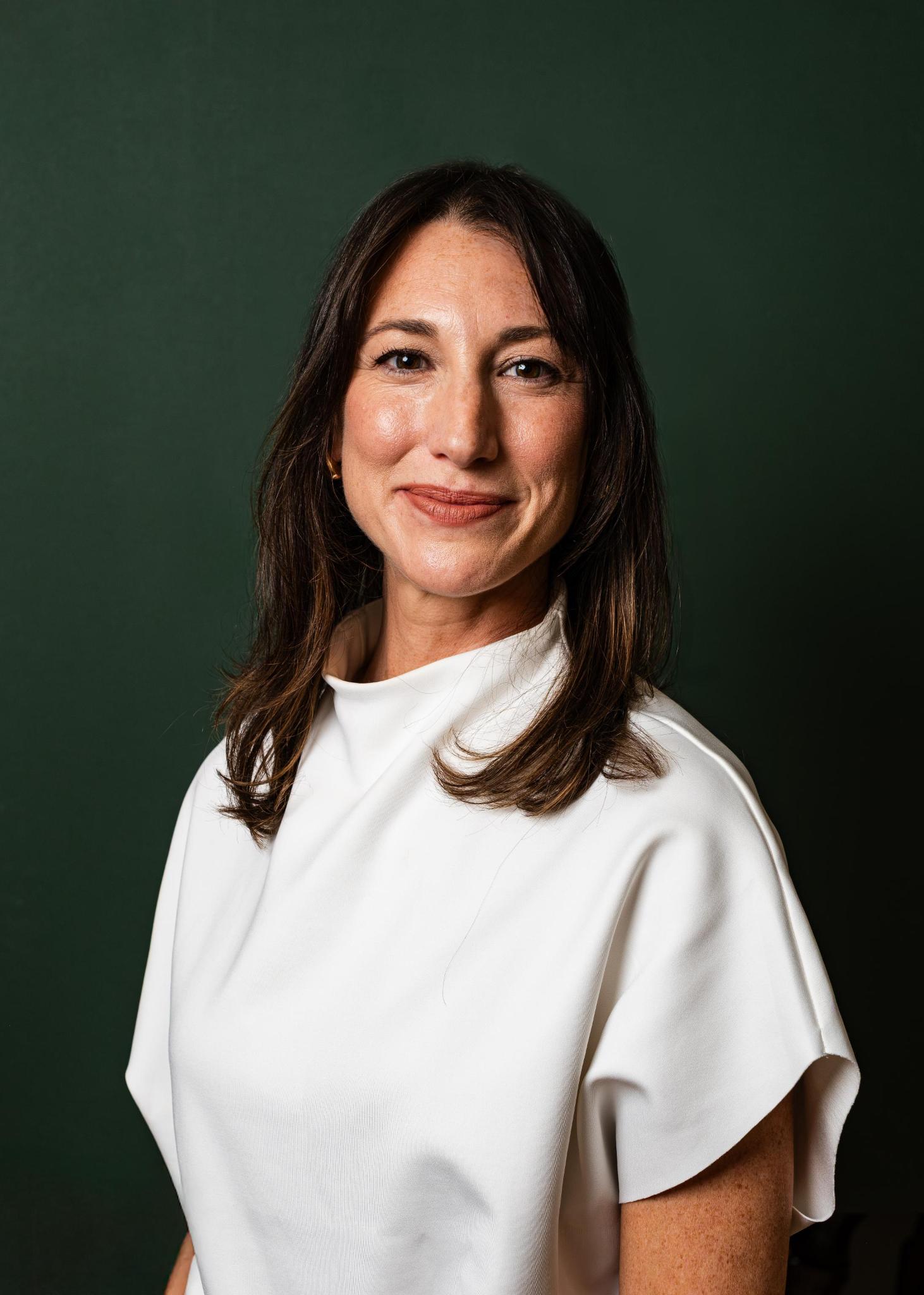 A woman with brown hair smiling and looking at camera